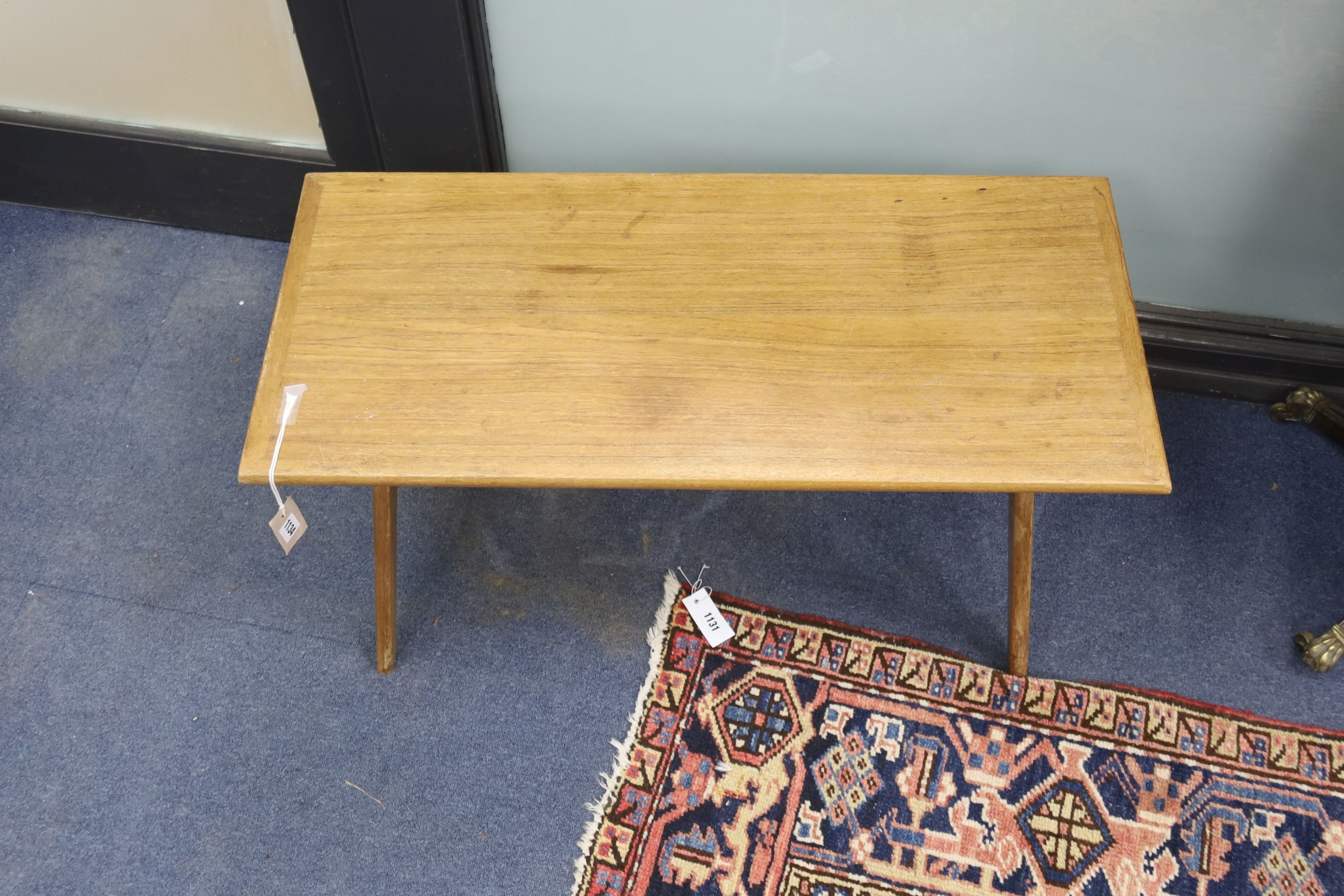 In the style of Pierre Jeanneret. A rectangular teak occasional table on compass leg, width 84cm, depth 37cm, height 46cm
